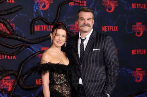 Millie bobby brown wows in a sheer naked lace dress while arm in arm with david harbour amid cast controversy